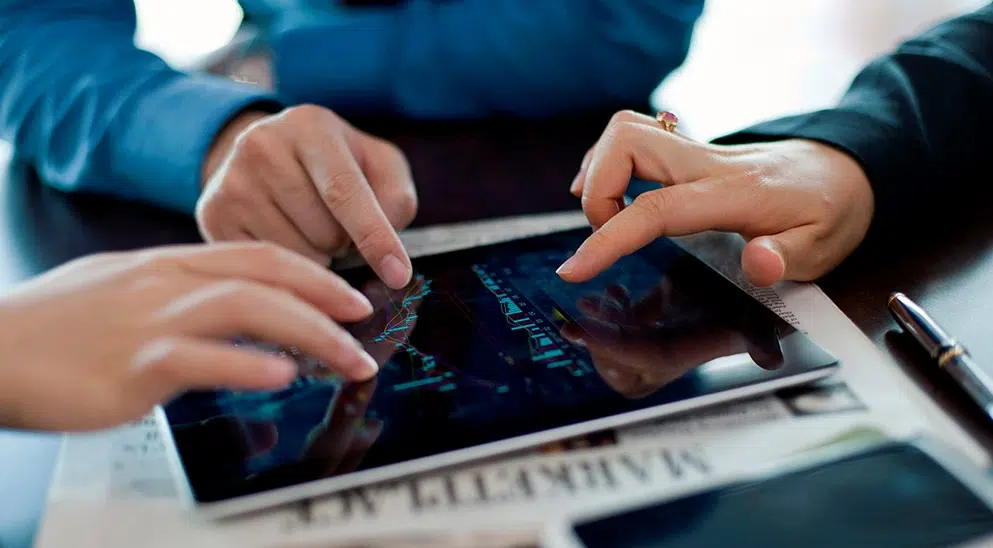 Drei Hände tippen auf einem ipad - BFS finance GmbH
